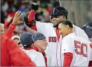  ?? ELISE AMENDOLA/AP PHOTO ?? Red Sox designated hitter David Ortiz gets a high-five at the dugout as he and Mookie Betts (50) celebrates Ortiz’s two-run homer against the Yankees in the eighth inning of Friday night’s game at Fenway Park in Boston. The Red Sox won 4-2.