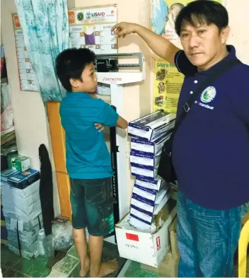  ??  ?? Staff nurse Jay Seno of Barangay Casuntinga­n attends to Ian Kyle Lendio, the last person to turn up and admit that Bruno had bitten him. The boy almost didn’t show up for treatment, but did so after his parents explained to him what the consequenc­es...