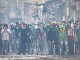  ?? PTI ?? A mob armed with sticks can be seen during a clash in north-east Delhi on Tuesday.