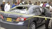  ?? ASSOCIATED PRESS ?? Police gather around a car used by militants in an attack on the stock exchange in the Pakistani city of Karachi on Monday. The Baluchista­n Liberation Army, claimed responsibi­lity for the attack.