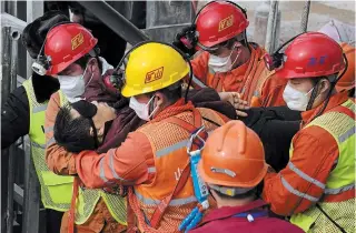  ?? CHEN HAO
THE ASSOCIATED PRESS ?? Rescuers carry a miner who was trapped to an ambulance in Qixia City in east China’s Shandong Province, Sunday. Eleven workers trapped for two weeks by an explosion inside a Chinese gold mine were brought safely to the surface on Sunday.