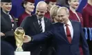  ?? Josek/AP ?? Vladimir Putin strokes the World Cup trophy while standing alongside Gianni Infantino, the FIFA President, after the 2018 World Cup final. Photograph: Petr David