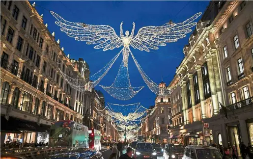  ??  ?? Festive air: shoppers walking below christmas lights along regent street in central London on the last saturday before christmas. —aFP