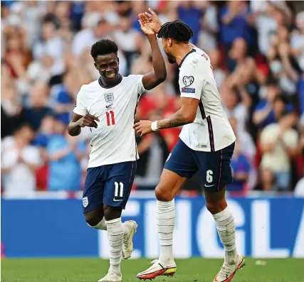  ?? Picture: Shaun Botterill/Getty ?? England’s Bukayo Saka celebrates his goal against Andorra with Tyrone Mings