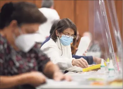  ?? Tyler Sizemore / Hearst Connecticu­t Media file photo ?? Poll workers prepare absentee ballots for counting at Town Hall in Greenwich on Nov. 2, 2020. Any registered voter in the 36th Senate District can vote by absentee ballot in the Aug. 17 special election.