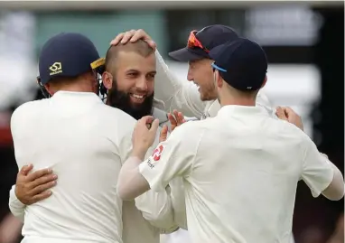  ??  ?? SUPER SIX: England’s Moeen Ali, second left, celebrates taking the fifth of his six wickets in the South African second innings.