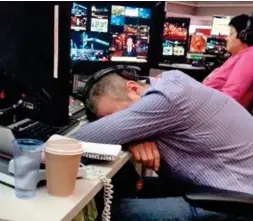  ??  ?? Head down: A sleepy worker has forty winks at his desk