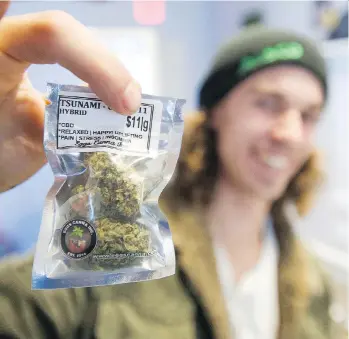  ?? JASON PAYNE ?? Isaac Mayville displays a purchase from Eggs Canna dispensary in Vancouver on Thursday. Illegal pot shops are having to adjust their practices with the looming legalizati­on of marijuana next month.