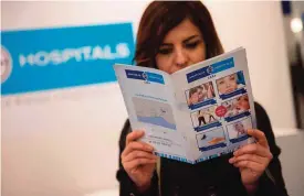  ??  ?? BERLIN: This file photo taken on March 08, 2017 shows a hostess posing with informatio­n material for a hospital in Turkey at a section for medical tourism at the Internatio­nal Tourism Trade Fair (ITB) on March 8, 2017. —AFP photos