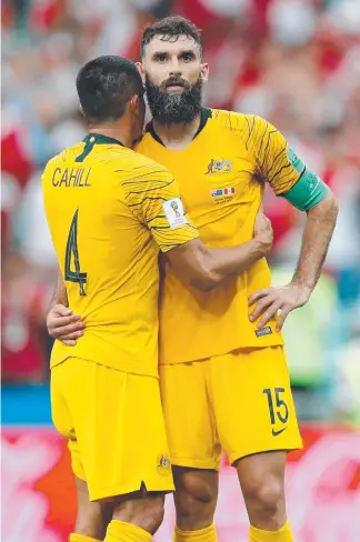  ?? Picture: AFP ?? Australia's Tim Cahill and captain Mile Jedinak embrace after the Socceroos exited the World Cup with a 2-0 defeat by Peru in Sochi.