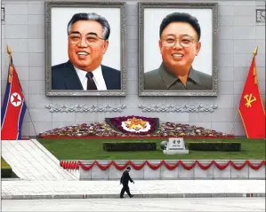  ?? DAMIR SAGOLJ/REUTERS ?? SANTAI DULU, KAMERAD: Tentara Korea Utara menikmati es krim di pusat Kota Pyongyang kemarin (16/4). Foto atas, warga melintas di depan potret raksasa pendiri Korea Utara mendiang Kim Il-sung dan mantan pemimpin Korut mendiang Kim Jong-il di Pyongyang...