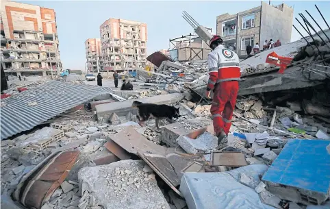  ?? AP ?? A rescue worker and sniffer dog search for survivors after an earthquake in Sarpol-e-Zahab, Iran, yesterday.
