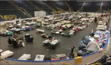  ?? PHOTOS BY JAY REEVES — THE ASSOCIATED PRESS ?? Cots cover the floor of Hertz Arena, an ice hockey venue that has been transforme­d into a massive relief shelter, in Estero, Fla., on Saturday.