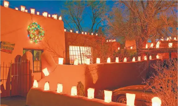  ?? COURTESY OF THE TAOS TOURISM AND MARKETING DEPARTMENT ?? A soft glow marks the Lighting of Ledoux on Dec. 2 in Taos as the historic street is lit with farolitos and bonfires.