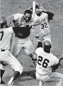  ?? ASSOCIATED PRESS FILE PHOTO ?? Here’s hoping the fans sitting next to each other wearing the jerseys of Juan Marichal and John Roseboro got along better than the players after Marichal swung a bat at Roseboro in this incident on Aug. 22, 1965.