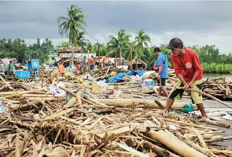  ?? AFP ?? Residents gather debris from their destroyed houses after typhoon Kammuri hit the city of Sorsogon, south of of Manila, on Tuesday.