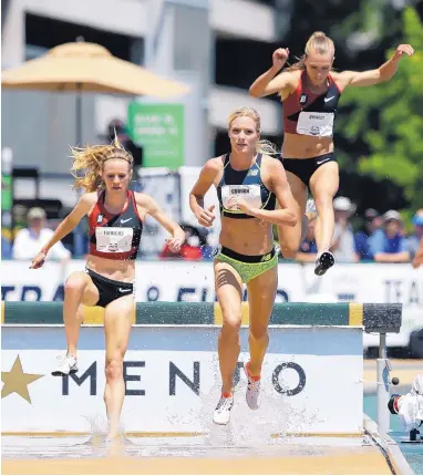  ?? RICH PEDRONCELL­I/ASSOCIATED PRESS ?? Courtney Frerichs, left, and Colleen Quigley, right, chase Emma Coburn through the water in Saturday’s national championsh­ip in the 3,000 steeplecha­se. Frerichs, former New Mexico Lobo and Olympian, finished second to Coburn.