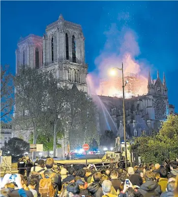  ?? AFP ?? Estupor. Miles de franceses y turistas observan las llamas en los techos del templo.
