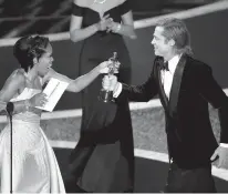  ?? CHRIS PIZZELLO/ASSOCIATED PRESS ?? Regina King presents Brad Pitt with the award for best performanc­e by an actor in a supporting role at the Oscars.