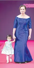  ??  ?? MARGIE MORAN-Floirendo, Miss Universe 1973, wearing a gown by Ito Curata, with granddaugh­ter Cosima wearing Rustan’s, at the Fashion Can Serve gala.