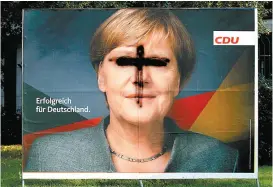  ??  ?? En la ciudad de Colonia dañan cartel proselitis­ta de Merkel.