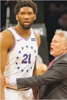  ?? GETTY ?? Brett Brown (r.) holds back Joel Embiid during scuffle.