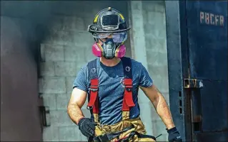  ?? PHOTOS BY LANNIS WATERS / THE PALM BEACH POST ?? In a demonstrat­ion at Palm Beach County Fire Rescue on Thursday, firefighte­r Michael McKeehan wears one of the new half-masks that are being distribute­d this week to all Palm Beach County firefighte­rs to help protect against carcinogen­s in smoke-laden environmen­ts.