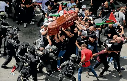  ?? AP ?? Israeli police clash with mourners as they carry the casket of slain Al Jazeera journalist Shireen Abu Akleh during her funeral in East Jerusalem. Thousands turned out for what is believed to be the city’s largest Palestinia­n funeral in more than two decades.