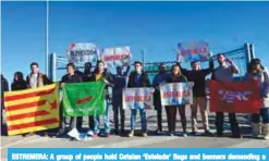  ?? —AFP ?? ESTREMERA: A group of people hold Catalan ‘Estelada’ flags and banners demanding a republic as they wait for the release of some Catalan former ministers, outside the Estremera prison yesterday.