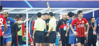  ?? — AFP photo ?? Referee Guo Baolong shows a yellow card to Shanghai SIPG’s Lv Wenjun during the Chinese Super League (CSL) match between Shanghai SIPG and Jiangsu Suning in Suzhou, in China’s eastern Jiangsu province.