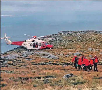  ?? Photograph courtesy Arran Mountain Rescue Team ?? The rescue team carry the injured woman to the awaiting rescue helicopter.