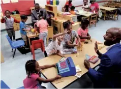  ?? STAFF PHOTO BY DOUG STRICKLAND ?? Councilman Anthony Byrd, right, and councilman Erskine Oglesby, back left, play with students at the Avondale Head Start Center on Thursday.