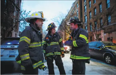  ?? Kena Betancur / AFP / Getty Images ?? Firefighte­rs work on the scene of an apartment building fire in the Bronx borough of New York City.