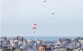  ?? PHOTO: AFP ?? Parachutes of humanitari­an aid dropping over the besieged Palestinia­n territory yesterday.