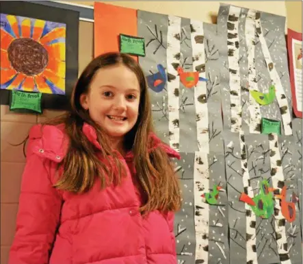  ?? LEAH MCDONALD - ONEIDA DAILY DISPATCH ?? Sloane Clinch, 8, poses in front of her artwork at the Oneida City School District’s district-wide art show at Otto Shortell Middle School on Tuesday, March 20, 2018. The show runs until April.
