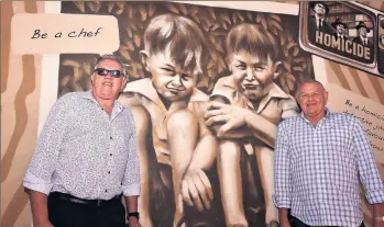  ??  ?? Barry and Ron Iddles stand either side of a section of mural based on a childhood photo.