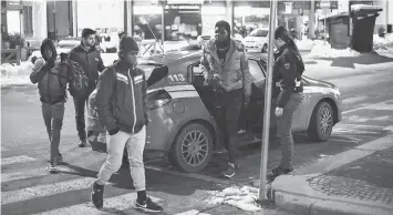  ??  ?? Above left, Italian Police officers escort back to the train station three migrants after convincing them to give up the attempt to reach France at night with an invalid document in Bardonecch­ia, Italy on Jan 13. • French Police officers bring back to...