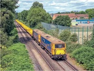  ?? KEN BRUNT ?? GBRf ‘Shoeboxes’ Nos. 73136 Mhairi +73213 Rhodalyn double-head a rake of 20 new Wascosa FEA wagons at Virginia Water on July 6, running as the 4Y68/09.39 Tonbridge West Yard to Eastleigh East Yard.