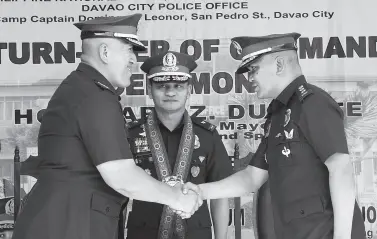  ??  ?? OUTGOING city police director Col. Alexander Tagum shakes hand with his successor, Col. Kirby John Kraft, as Police Regional Office acting director Brig. Gen. Filmore Escobal looks on during the turnover ceremony inside Camp Capt. Domingo Leonor along San Pedro Street on Friday. BING GONZALES