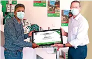  ?? ?? H.A. Gayan Aravinda, Distributo­r for AMW Castrol in Anuradhapu­ra, receiving a souvenir from Peter Mackenzie, Managing Director – AMW Group