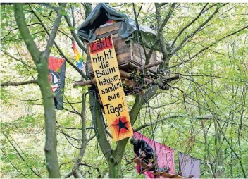  ?? FOTO: DPA ?? Ein Baumhaus von Aktivisten im Hambacher Forst, die Worte auf dem Plakat sind nicht an Kerpens Bürgermeis­ter gerichtet gewesen. Die Polizei sieht im Forst aber Linksradik­ale beheimatet, die immer wieder Gesetze brechen.