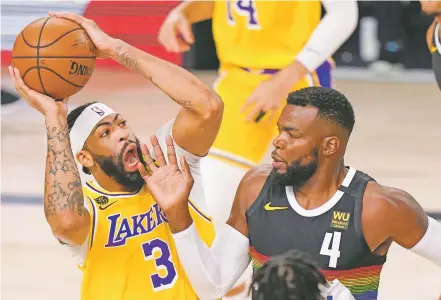  ?? MARK J. TERRILL/ASSOCIATED PRESS ?? The Lakers’ Anthony Davis, guarded by the Nuggets’ Paul Millsap, scored 34 points Thursday in Lake Buena Vista, Fla. The Lakers took a 3-1 series lead and are one win away from the NBA Finals for the first time in 10 years.