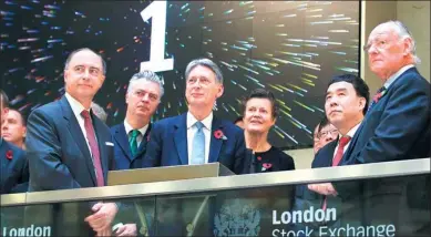  ?? PETER NICHOLLS / REUTERS ?? British Chancellor of the Exchequer Philip Hammond (center), Bank of China chairman Tian Guoli (second right) and London Stock Exchange Group CEO Xavier Rolet (left) open the markets for the start of trading at the London Stock Exchange on Nov 10, 2016.