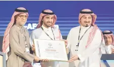  ?? — AFP photo ?? AFC president Salman bin Ibrahim al-Khalifa (left) presents Saudi Arabia’s Minister of Sports and Youth Abdulaziz bin Turki al-Faisal al-Saud (centre) with a plaque, appointing Saudi Arabia as the host of the 2027 AFC Asian Cup.