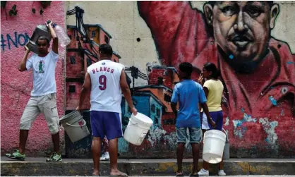 ??  ?? Venezuelan­s head to collect water from a sewage canal at the river Guaire in Caracas. President Nicolás Maduro has alleged a US attack crippled the country’s electrical system. Photograph: Juan Barreto/AFP/Getty Images