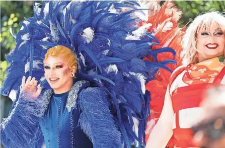  ?? PHOTOS BY COURTNEY HERGESHEIM­ER/ COLUMBUS DISPATCH ?? Drag queens from Palmas Tropical Escape bar wave to the crowds Saturday in Downtown Columbus.