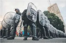  ??  ?? La policía resguarda el Ministerio de Desarrollo Social durante las protestas de ayer, en Buenos Aires.