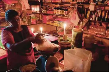  ??  ?? PENIAGA terpaksa menggunaka­n lilin untuk menjalanka­n perniagaan di tingkat bawah di Pasar Besar Seremban.