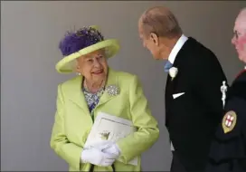  ?? PHOTO/ALASTAIR GRANT, POOL ?? Britain’s Queen Elizabeth talks with Prince Philip after the wedding ceremony of Prince Harry and Meghan Markle at St. George’s Chapel in Windsor Castle in Windsor, near London, England, on Saturday. AP