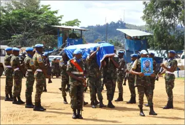  ??  ?? UN peacekeepe­rs serving in the United Nations Organisati­on Stabilisat­ion Mission in the Democratic Republic of the Congo (MONUSCO) carry the coffin of their colleague who was killed during clashes with militias in Beni territory. — Reuters photo